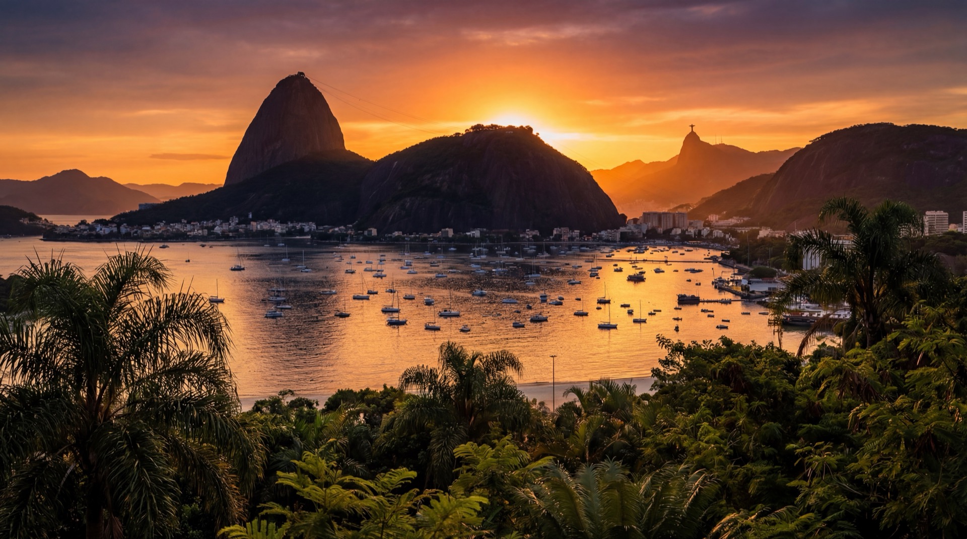 Cinematic golden hour panorama of Rio de Janeiro from Morro da Urca, showing Sugarloaf Mountain silhouetted against a warm orange sky, Guanabara Bay shimmering below, Cristo Redentor visible on Corcovado in the distance, tropical vegetation in the foreground, sailboats dotting the water, vibrant and warm color palette